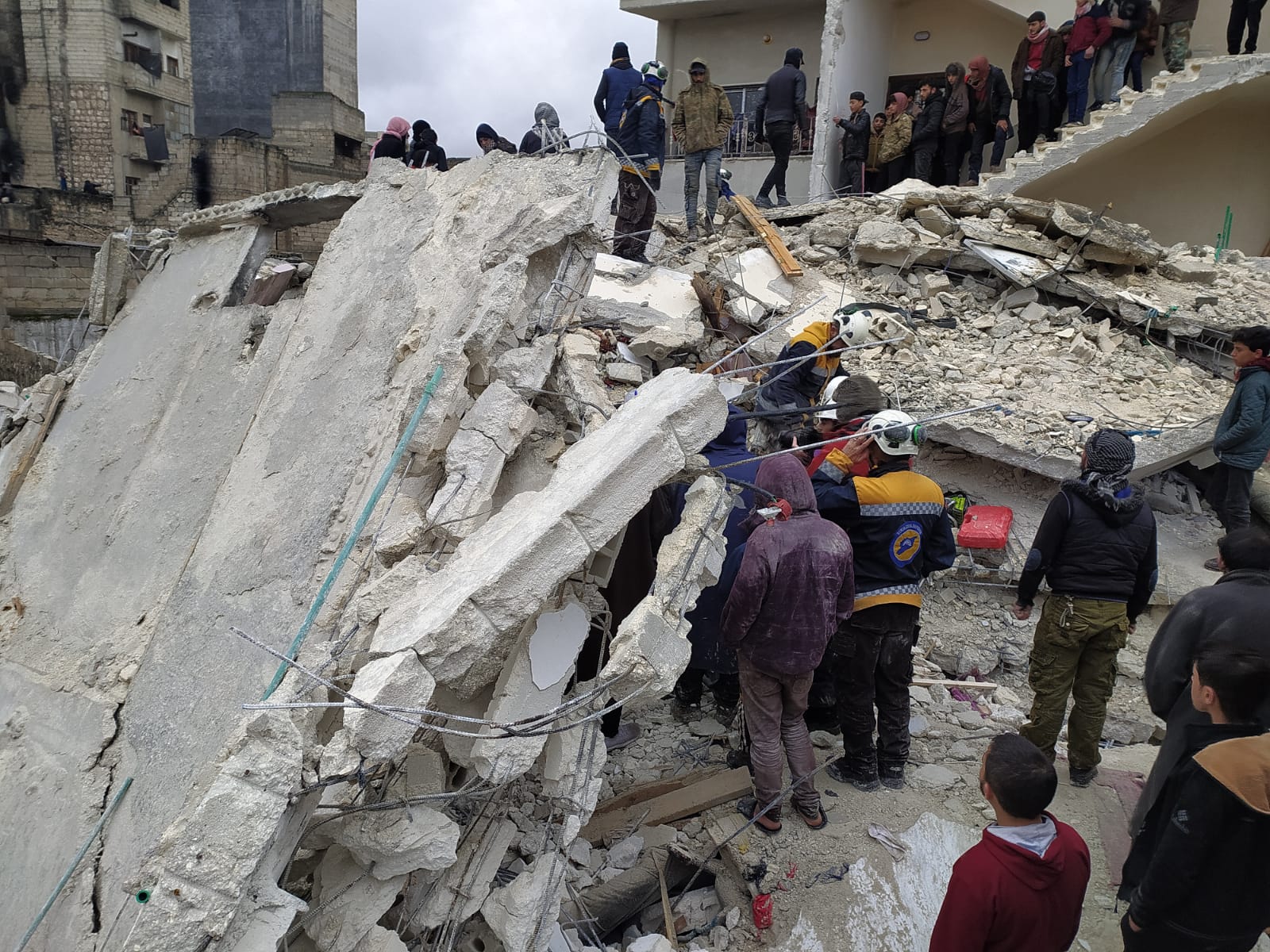 People searching for other buried in the rubble of a building after the earthquake in Syria