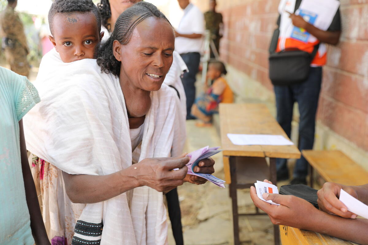 A woman and her child, affected by Tigray crisis, receive multipurpose cash assistance from World Vision