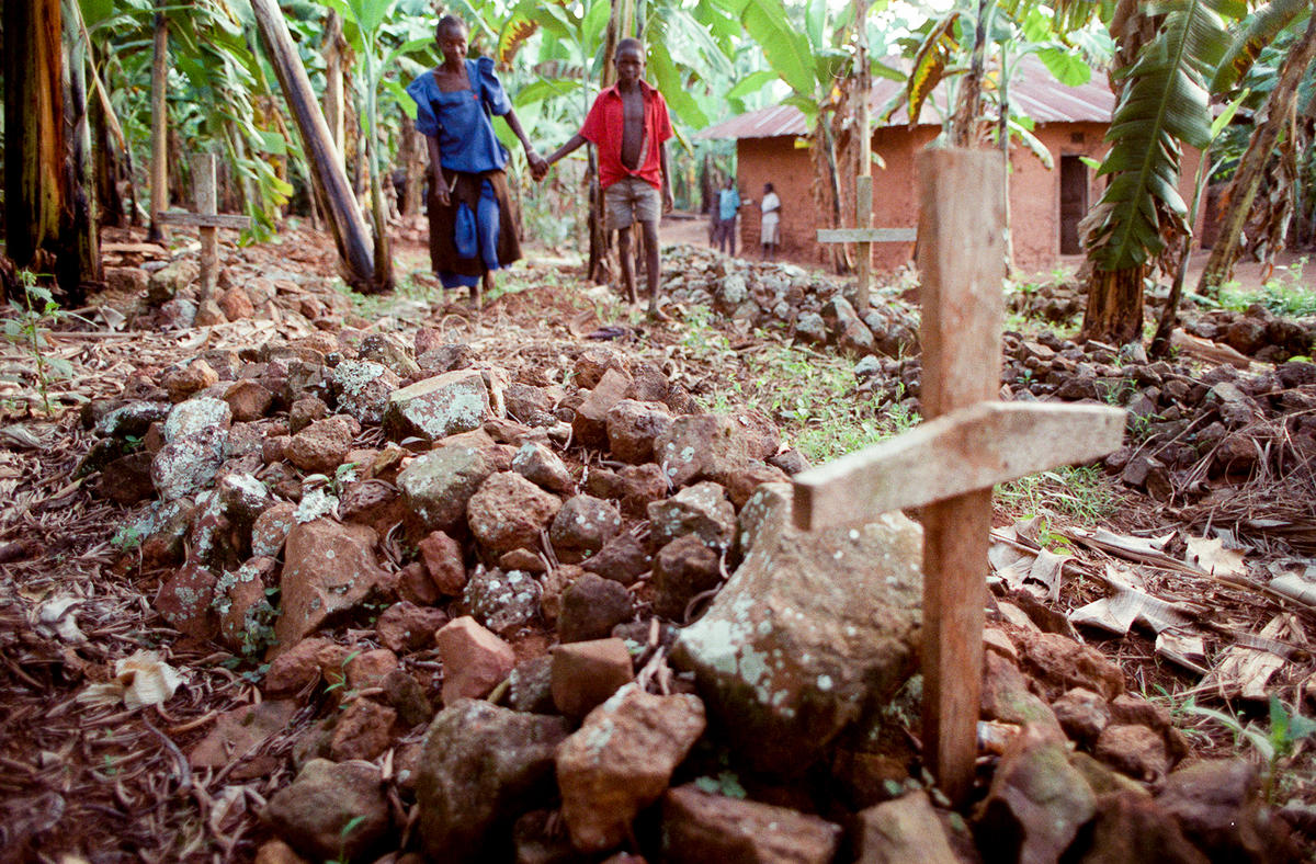 Relatives walk among the graves near their house.